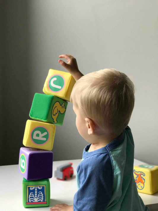 Toddler stacking colorful soft blocks during independent sensory play