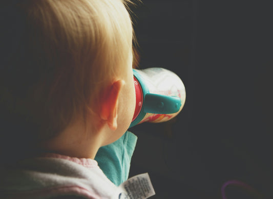 Toddler drinking from a training cup