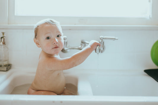 Baby playing happily during bath time