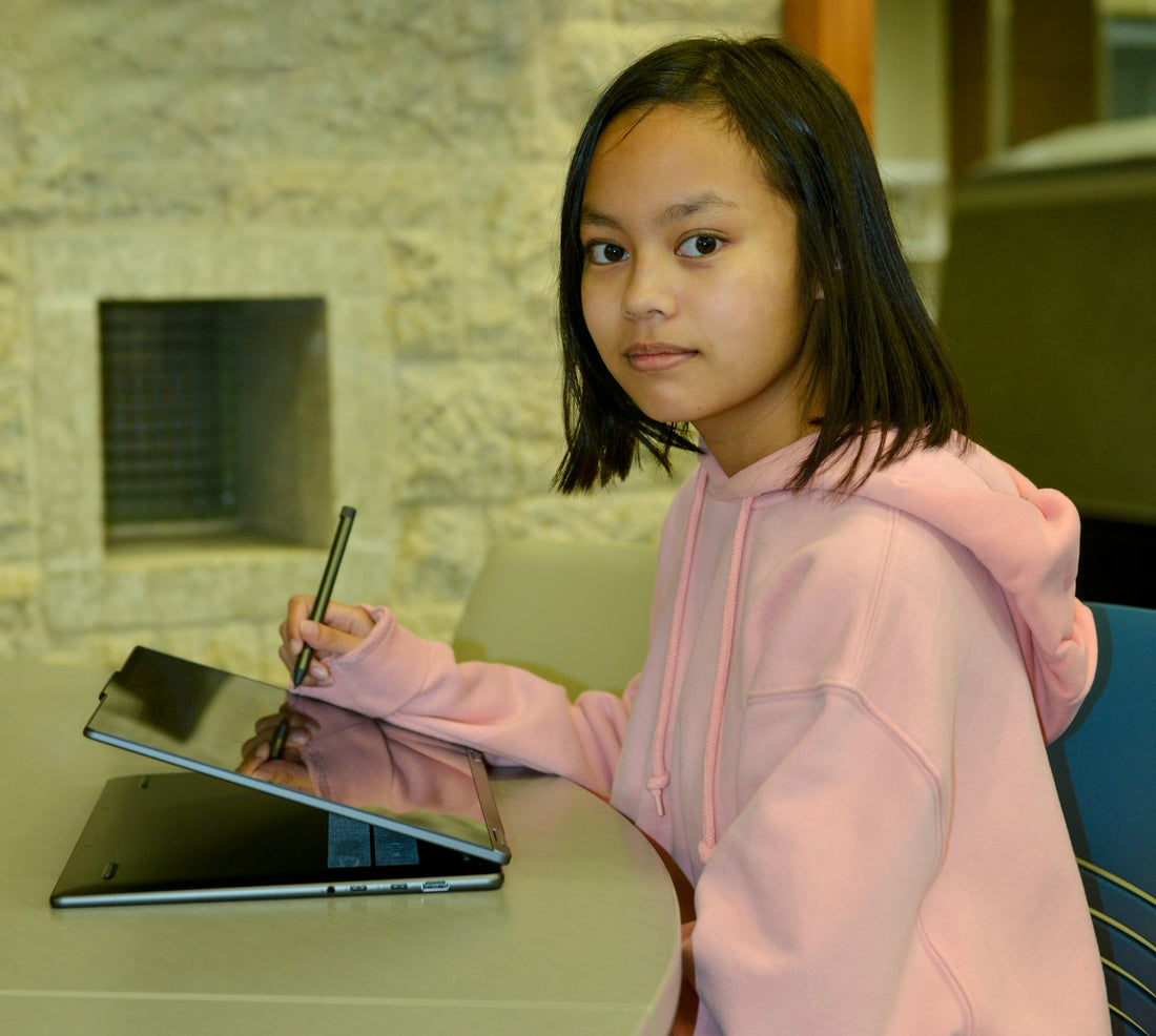 Child drawing on an LCD doodle board with a stylus