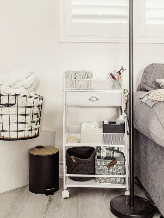 Organized rolling cart filled with diaper caddy baskets and baby essentials